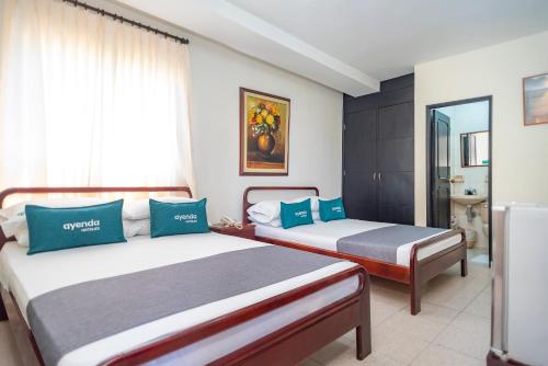 a bedroom with two beds and a window at Ayenda 1309 Villa Dilia in Barranquilla
