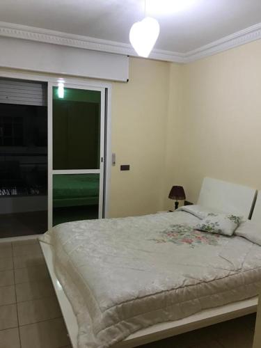 a bedroom with a large bed in a room at Cala Iris Appartement de vacances in Martil