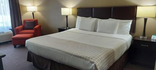 a hotel room with a large bed and a chair at Parkwood Inn & Suites in Manhattan