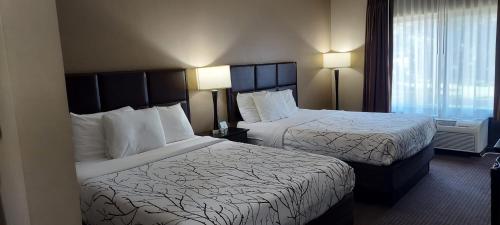 a hotel room with two beds and a window at Parkwood Inn & Suites in Manhattan