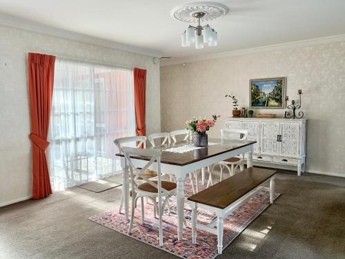 a dining room with a white table and chairs at Cosy House in Chartwell, Hamilton-Private Garden & Shopping Mall in Hamilton