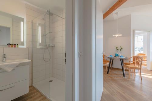a bathroom with a shower and a sink and a table at Rügen Vilm mit Seeblick und Sonnenterasse in Ostseebad Sellin