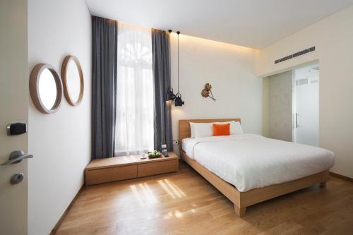 a bedroom with a bed and a large window at Hotel Clover 769 North Bridge Road in Singapore