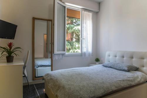 a bedroom with a bed and a window and a mirror at FLY HOUSE BOLOGNA...un appartamento al volo in Bologna