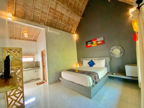 - une chambre avec un lit et une télévision dans l'établissement Baliwid Villa Ubud, à Ubud