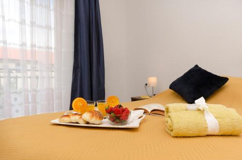 a tray of fruit and bread on a bed at Apartments Ivana in Murter