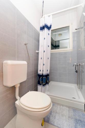 a bathroom with a toilet and a shower curtain at Apartments Ivana in Murter