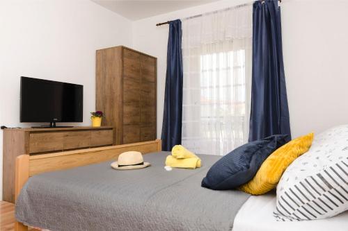 a bedroom with a bed with a flat screen tv at Apartments Ivana in Murter