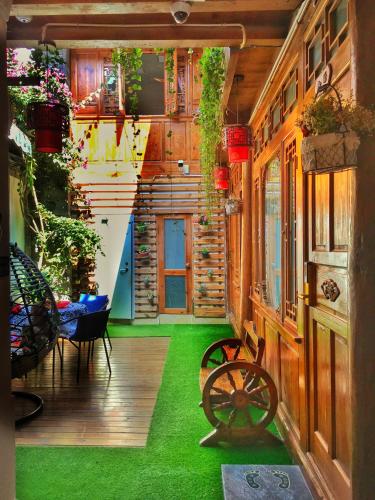 a room with a green floor and a wooden building at Juxian Boutique Homestay in Lijiang