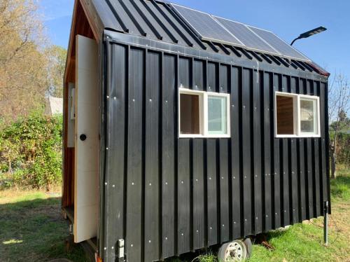 伊斯拉德邁波的住宿－Tiny House Remanso del Espíritu，一座黑色的小型房屋,设有太阳能屋顶