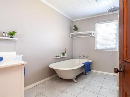 a white bathroom with a tub and a sink at Cudgee in Currarong