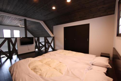 1 dormitorio con 1 cama grande y puerta negra en るり渓清流台Z-5-6号棟 en Habu