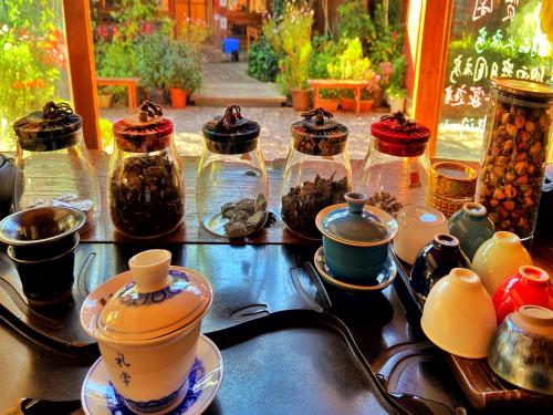 a table filled with jars and bowls of food at Juxian Boutique Homestay in Lijiang