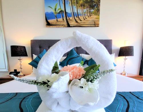 A bed or beds in a room at Palm Cove Beach Apartment
