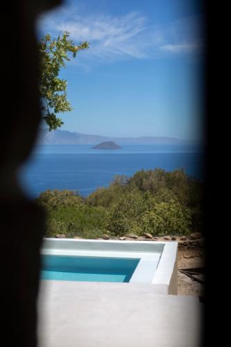 a swimming pool with a view of the ocean at My Old Stone House in a 2 000 sqm private garden with Fab Glamping Tent in Mandrakion