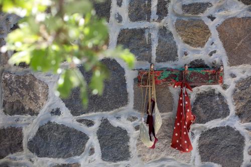 a red and white umbrella hanging on a stone wall at My Old Stone House in a 2 000 sqm private garden with Fab Glamping Tent in Mandrakion