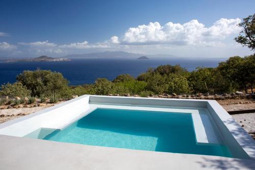 a swimming pool with a view of the ocean at My Old Stone House in a 2 000 sqm private garden with Fab Glamping Tent in Mandrakion