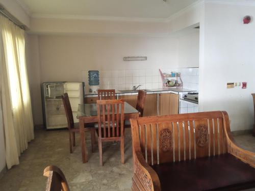 a kitchen with a table and chairs and a kitchen with a stove at PENGINAPAN KONDOMINIUM CARITA - PAK BoS in Carita