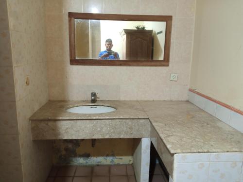 a person taking a picture of a bathroom sink at PENGINAPAN KONDOMINIUM CARITA - PAK BoS in Carita