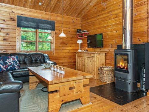 エーベルトフトにある6 person holiday home in Ebeltoftの暖炉付きのリビングルーム(ログキャビン内)