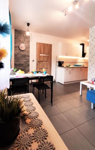 a kitchen and dining room with a table and chairs at Apartamenty Pilsko Korbielów komfortowe mieszkania dla rodzin i narciarzy w Beskidach in Korbielów