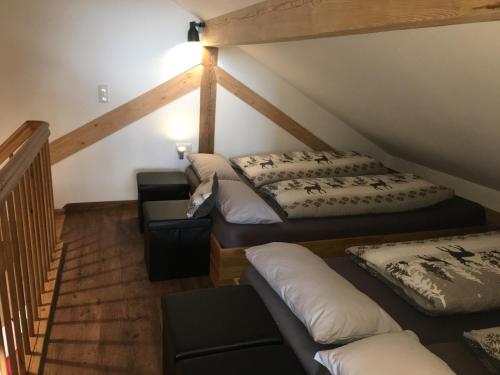 a attic room with two beds and a staircase at Ferienscheune Maria in Lichtenfels