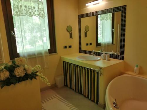 y baño con lavabo y espejo. en B&b Campovolo, en Monzambano
