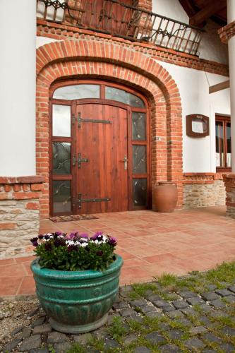 a large door to a building with a pot of flowers at St.Michael Panzió Lovaspark in Vasszentmihály