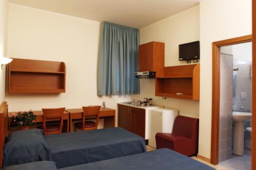 パレルモにあるResidence Hotel Gloriaのベッド1台付きの部屋、テーブル付きのキッチンが備わる客室です。