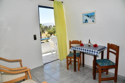 a dining room with a table and chairs and a balcony at 1-Bedroom Kos Olympia Apartment at Lambi Beach in Lampi