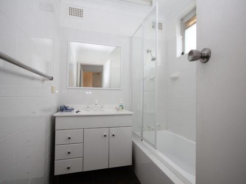 a white bathroom with a sink and a shower at Beachfront 4 Unit 4 of 12 Bundella Ave LC in Lake Cathie