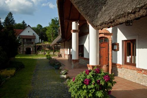 a courtyard of a house with flowers in a yard at St.Michael Panzió Lovaspark in Vasszentmihály