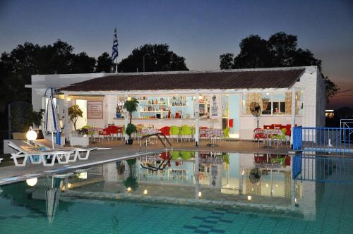 a building with a swimming pool in front of a house at 1-Bedroom Kos Olympia Apartment at Lambi beach in Kos Town