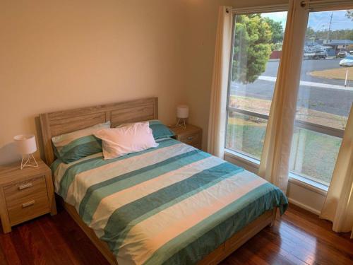 1 dormitorio con cama y ventana grande en 38 Alfred Street, en North Haven