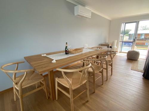 a dining room with a wooden table and chairs at Alma Beach Haven in North Haven