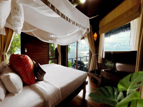 a bedroom with a bed and a large window at Koh Tao Cabana in Koh Tao