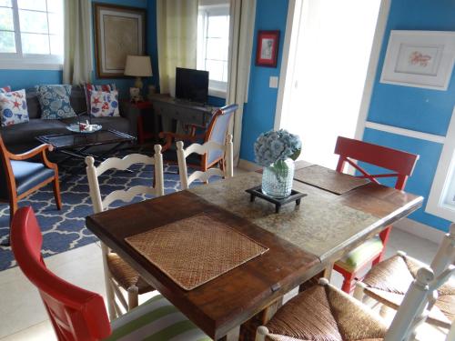 a living room with a wooden table and chairs at Rollezz Villas Beach Resort in Old Bight
