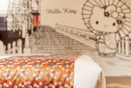 a bed in a room with a fan on the wall at RESI STAY NISHIKI in Kyoto