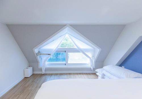 a bedroom with a white bed and a window at CAMP Jirisan Parkview in Gurye