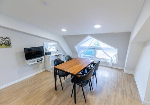 a dining room with a table and chairs and a window at CAMP Jirisan Parkview in Gurye