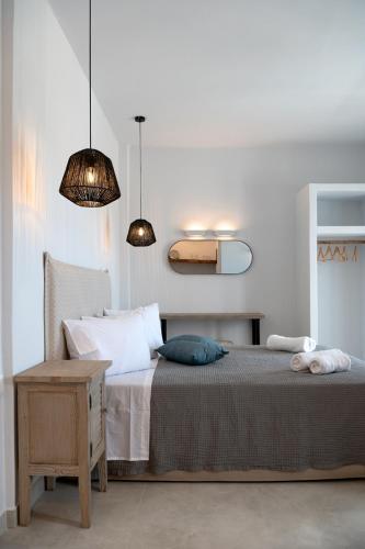 a bedroom with a bed and two pendant lights at Drios Luxury Studios in Drios
