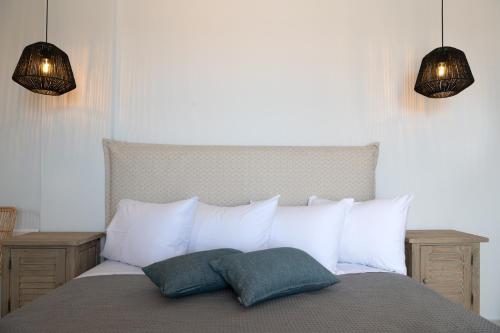 a bedroom with a bed with white pillows and two lights at Drios Luxury Studios in Drios