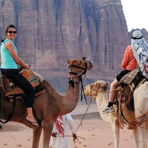 two people riding on camels in the desert at WADI RUM STAR WARS CAMP in Wadi Rum