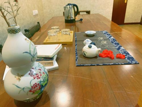a wooden table with a vase on top of it at Suzhou Jade Snow Lodge in Suzhou