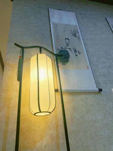 a lamp on the floor next to a book at Suzhou Jade Snow Lodge in Suzhou