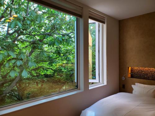 Un dormitorio con una gran ventana con un árbol en La Cachette, en Hakodate