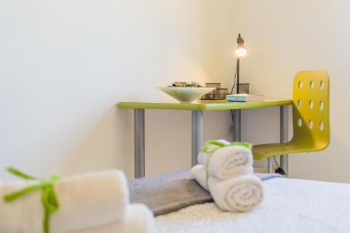 a room with a table and a yellow chair with towels at Bellavista Port de Soller in Port de Soller