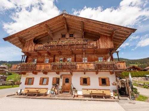 a large wooden building with a balcony on top at Beautiful flat in Kirchberg near the ski area in Kirchberg in Tirol