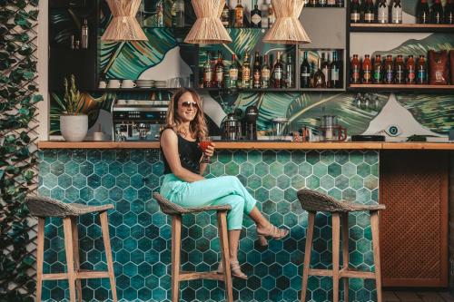 a woman sitting on a stool at a bar at Amoessa Boutique - Adults Only in Polykhrono