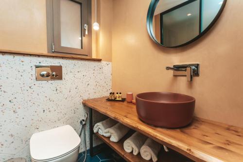 a bathroom with a wooden sink and a toilet at Amoessa Boutique - Adults Only in Polykhrono